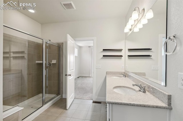 full bathroom with tile patterned floors, a shower stall, double vanity, and baseboards