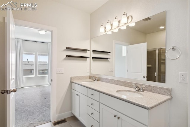 bathroom featuring double vanity, baseboards, and an enclosed shower