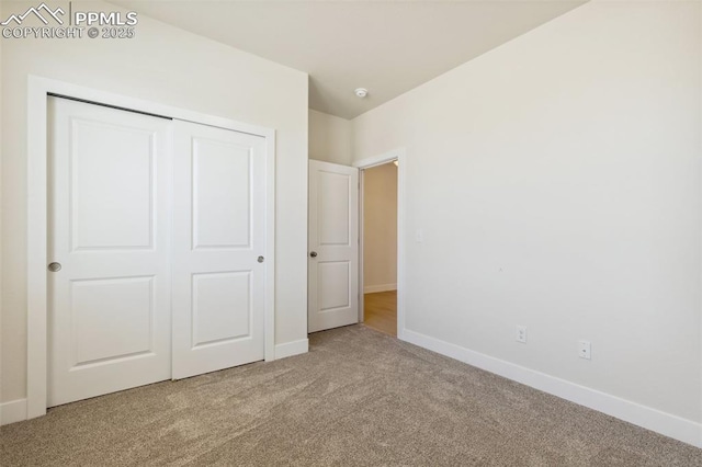 unfurnished bedroom featuring carpet flooring, a closet, and baseboards