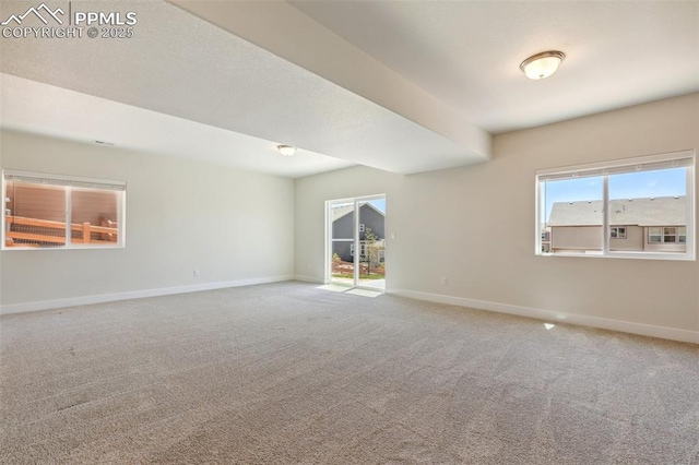 unfurnished room featuring carpet floors and baseboards