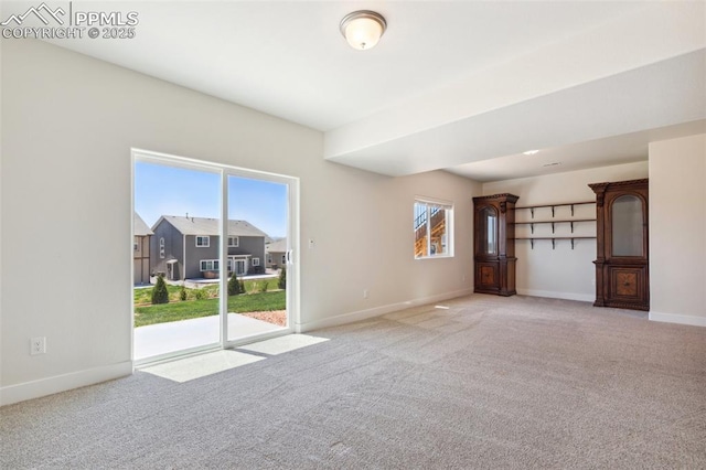 empty room with light colored carpet and baseboards