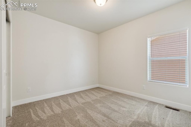 carpeted spare room with baseboards
