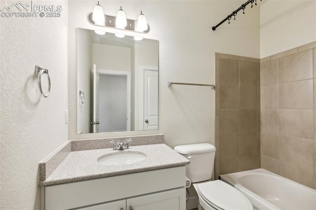 full bath featuring a textured wall, vanity, toilet, and shower / bathtub combination