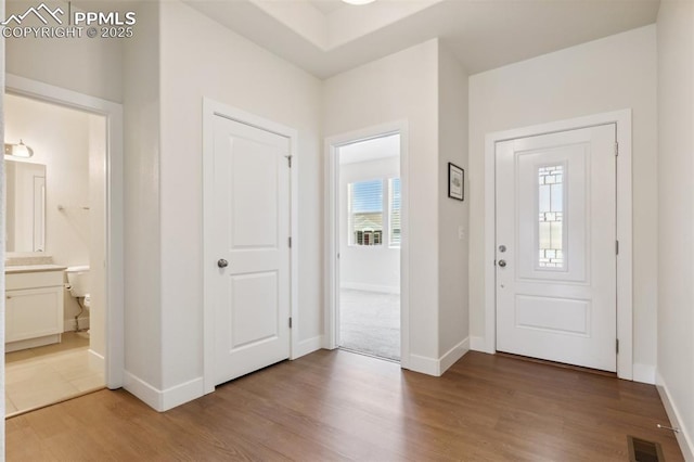 entryway with wood finished floors and baseboards