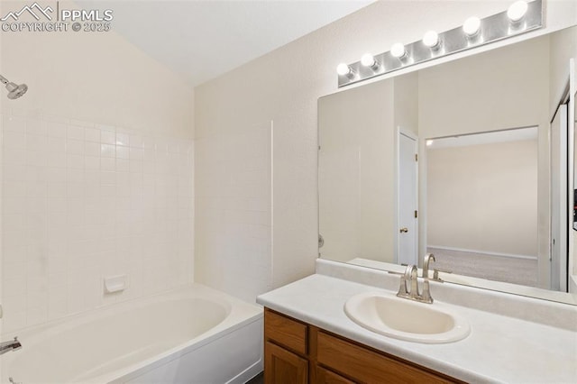bathroom featuring vanity, washtub / shower combination, and lofted ceiling