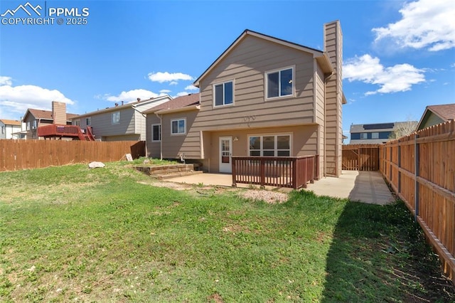 back of house with a yard, a patio, a chimney, and a fenced backyard