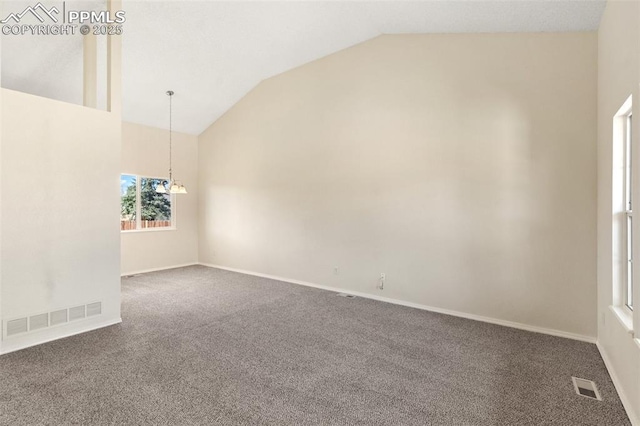 empty room with carpet, vaulted ceiling, a chandelier, and visible vents