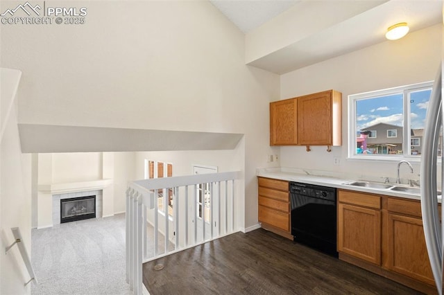 kitchen featuring brown cabinets, light countertops, a sink, and dishwasher