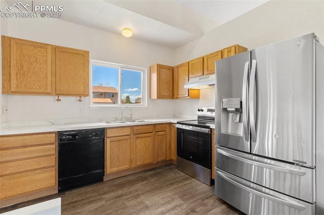 kitchen featuring dark wood finished floors, a sink, light countertops, under cabinet range hood, and stainless steel appliances