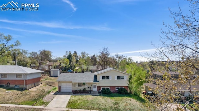 split level home with an attached garage, driveway, and a front lawn
