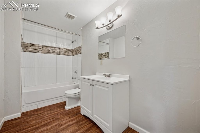 bathroom featuring visible vents, vanity, wood finished floors, toilet, and shower / bath combination