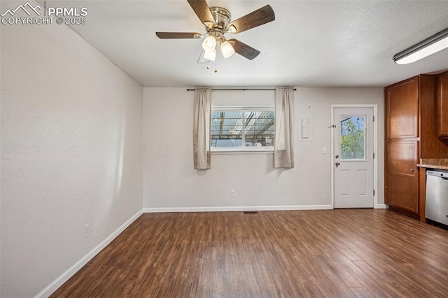 unfurnished living room featuring baseboards, ceiling fan, and dark wood-style floors