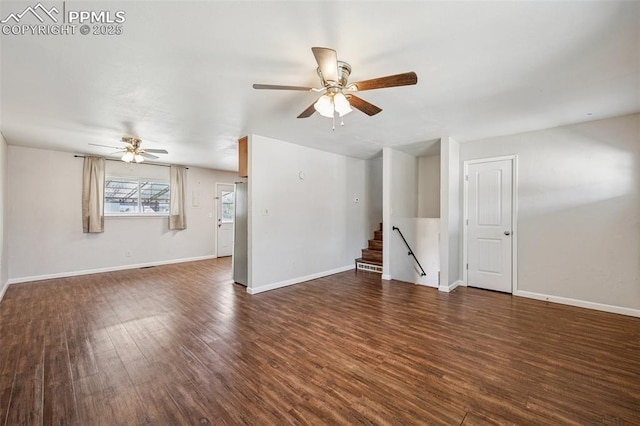 unfurnished living room with ceiling fan, wood finished floors, and stairway