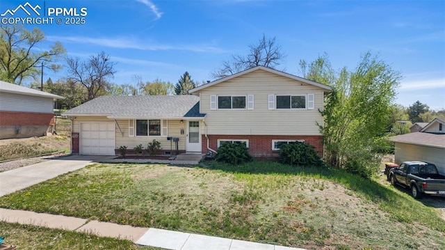 split level home with brick siding, a garage, a front lawn, and concrete driveway