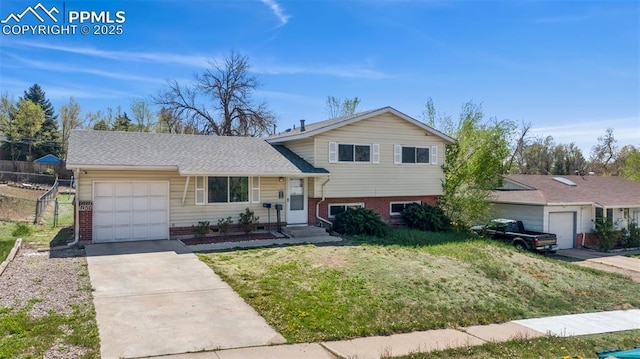 tri-level home with fence, a front yard, brick siding, concrete driveway, and an attached garage