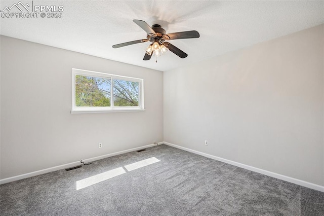 carpeted empty room featuring baseboards, ceiling fan, and visible vents