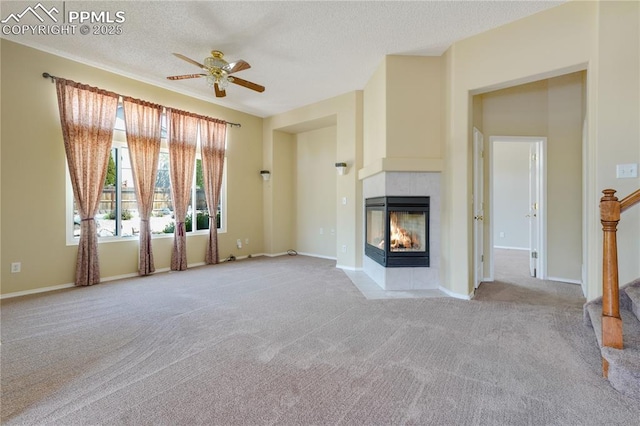 4282 Thornbury Way, Colorado Springs, CO 80922 - unfurnished living room with ceiling fan, light colored carpet, a tiled fireplace, a textured ceiling, and baseboards