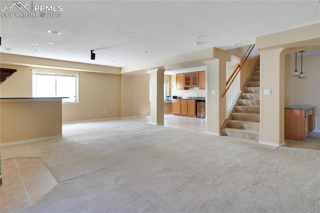 4282 Thornbury Way, Colorado Springs, CO 80922 - unfurnished living room featuring light colored carpet, a textured ceiling, stairway, recessed lighting, and beverage cooler