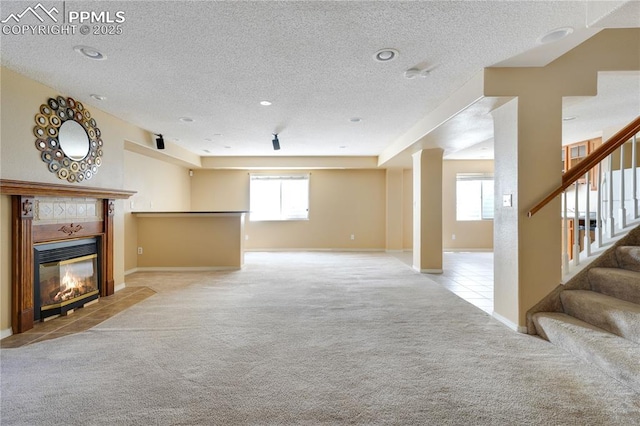 4282 Thornbury Way, Colorado Springs, CO 80922 - unfurnished living room with carpet floors, a textured ceiling, stairway, a tiled fireplace, and tile patterned floors