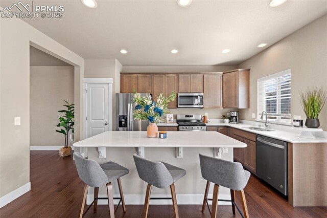2972 Namib Dr, Colorado Springs, CO 80939 - kitchen featuring a breakfast bar, baseboards, a center island, a sink, and appliances with stainless steel finishes