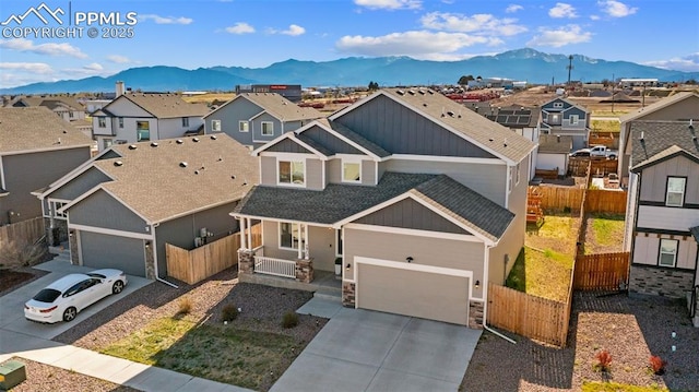 2972 Namib Dr, Colorado Springs, CO 80939 - view of front of home featuring covered porch, stone siding, concrete driveway, a mountain view, and a residential view