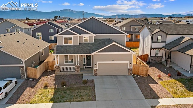 2972 Namib Dr, Colorado Springs, CO 80939 - view of front of home featuring covered porch, stone siding, concrete driveway, a mountain view, and a residential view