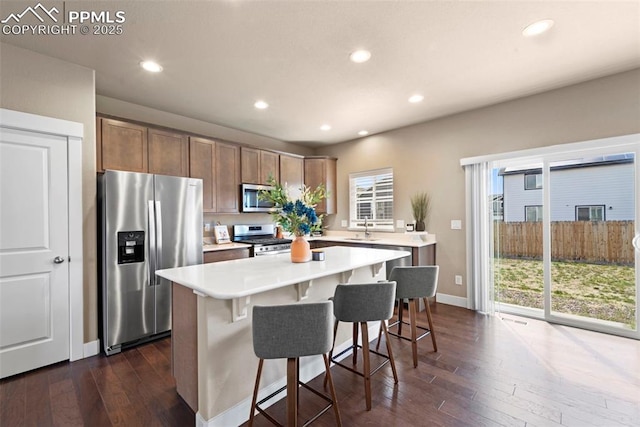 2972 Namib Dr, Colorado Springs, CO 80939 - kitchen with dark wood-style flooring, stainless steel appliances, a sink, and a center island