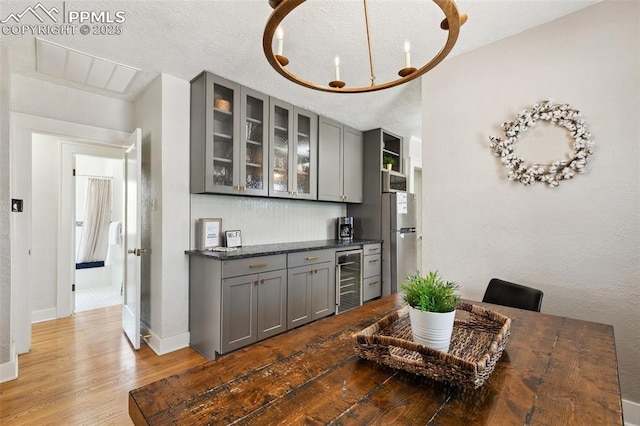 1415 E Boulder St, Colorado Springs, CO 80909 - bar with freestanding refrigerator, wood finished floors, beverage cooler, baseboards, and a dry bar