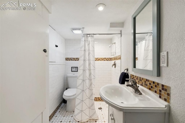 1415 E Boulder St, Colorado Springs, CO 80909 - bathroom with tile walls, tile patterned flooring, toilet, and a shower with shower curtain