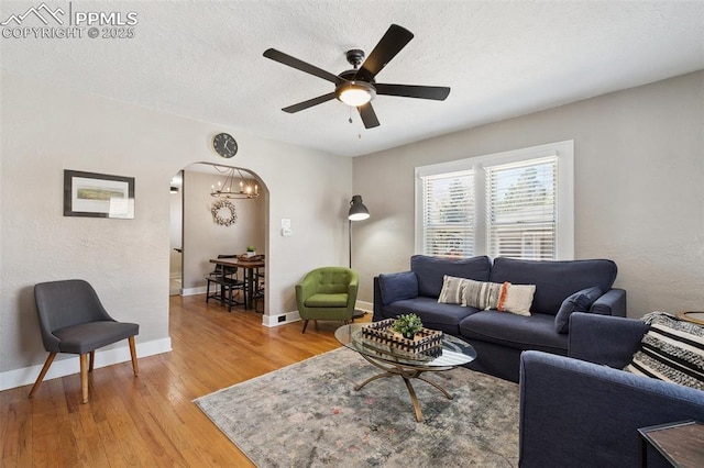 1415 E Boulder St, Colorado Springs, CO 80909 - living room with a textured ceiling, arched walkways, baseboards, ceiling fan with notable chandelier, and light wood finished floors