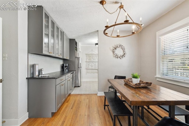 1415 E Boulder St, Colorado Springs, CO 80909 - kitchen featuring dark countertops, a notable chandelier, light wood-style flooring, stainless steel appliances, and gray cabinetry
