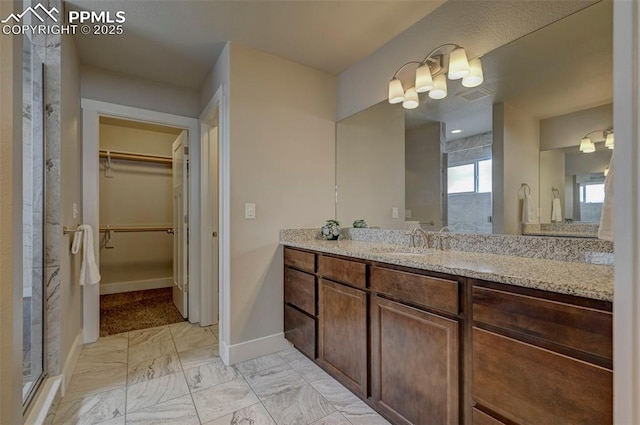 275 Eclipse Dr, Colorado Springs, CO 80905 - bathroom with a shower stall, marble look tiles, baseboards, a walk in closet, and a chandelier