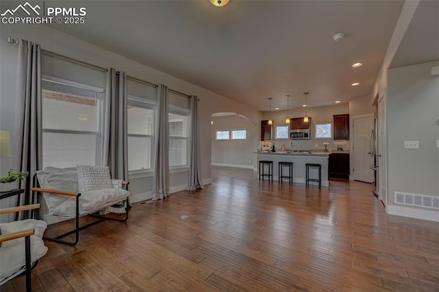275 Eclipse Dr, Colorado Springs, CO 80905 - living area with arched walkways, baseboards, wood finished floors, and recessed lighting