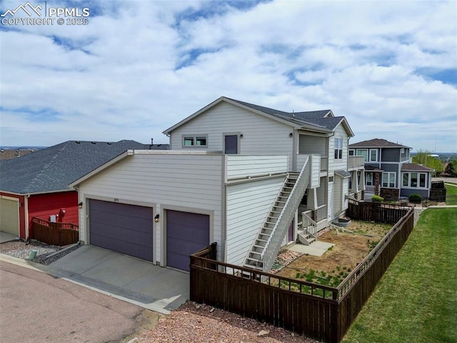 275 Eclipse Dr, Colorado Springs, CO 80905 - view of side of home with an attached garage, concrete driveway, and fence