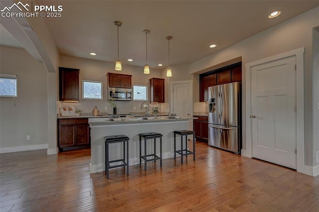 275 Eclipse Dr, Colorado Springs, CO 80905 - kitchen featuring stainless steel appliances, a breakfast bar area, recessed lighting, arched walkways, and baseboards