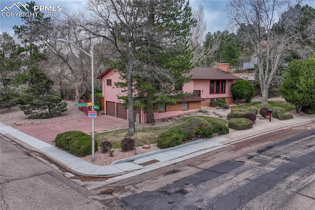 10 Gold Coin Ct, Colorado Springs, CO 80919 - view of front of property with an attached garage, a chimney, and driveway