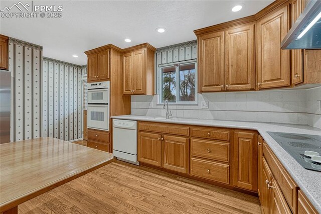 10 Gold Coin Ct, Colorado Springs, CO 80919 - kitchen featuring a sink, white appliances, extractor fan, wallpapered walls, and light wood-type flooring