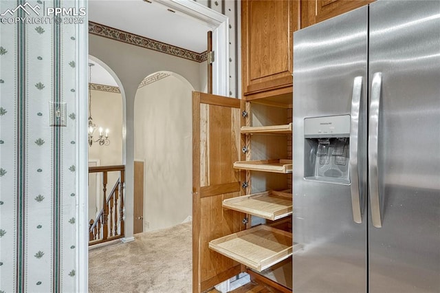 10 Gold Coin Ct, Colorado Springs, CO 80919 - interior space with open shelves, arched walkways, brown cabinetry, carpet, and stainless steel refrigerator with ice dispenser