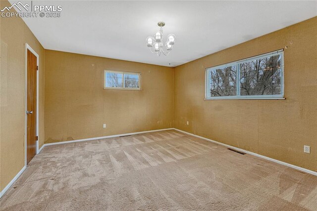 10 Gold Coin Ct, Colorado Springs, CO 80919 - carpeted empty room with baseboards, a notable chandelier, and visible vents