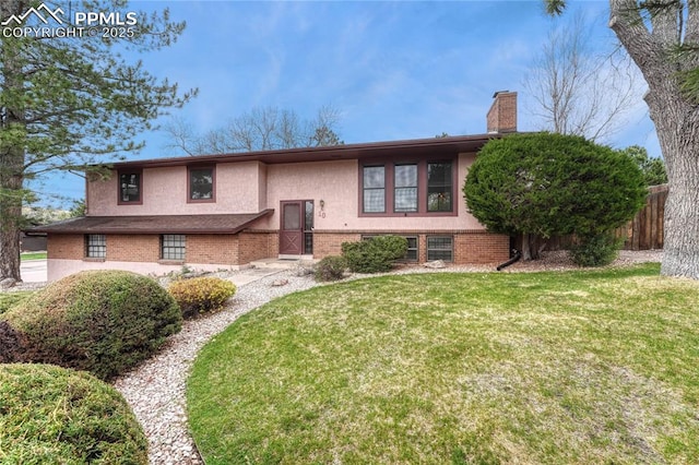 10 Gold Coin Ct, Colorado Springs, CO 80919 - split foyer home featuring a chimney, brick siding, fence, a front lawn, and stucco siding