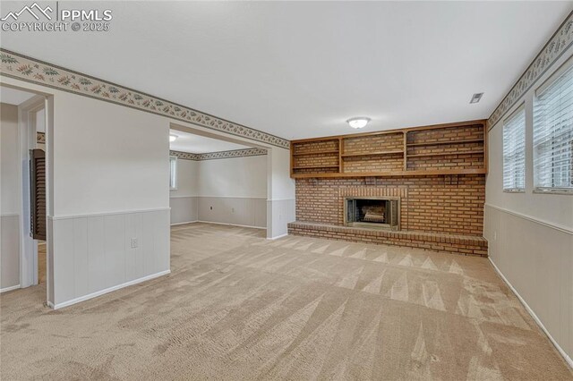 10 Gold Coin Ct, Colorado Springs, CO 80919 - unfurnished living room featuring carpet flooring, visible vents, a fireplace, and a wainscoted wall