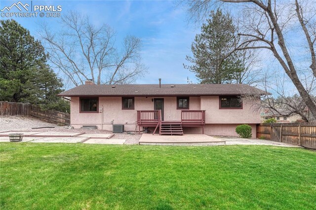 10 Gold Coin Ct, Colorado Springs, CO 80919 - back of property with a chimney, a lawn, a deck, a fenced backyard, and stucco siding