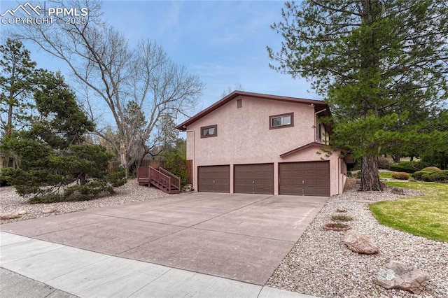 10 Gold Coin Ct, Colorado Springs, CO 80919 - view of side of home with a garage, stucco siding, and concrete driveway