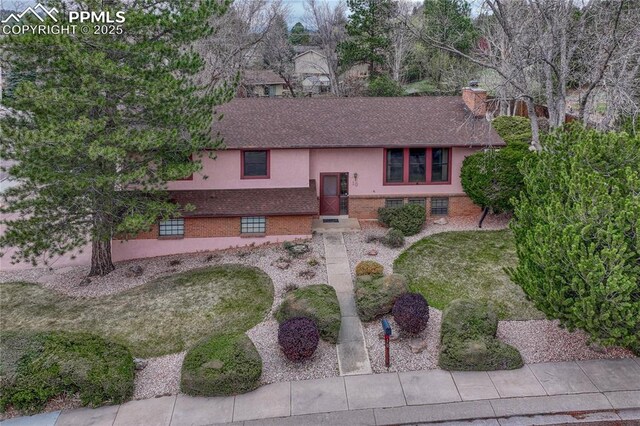 10 Gold Coin Ct, Colorado Springs, CO 80919 - split foyer home featuring brick siding, a shingled roof, and a chimney