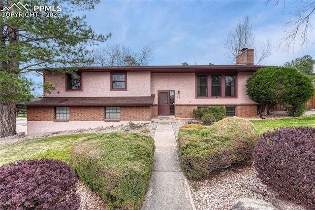 10 Gold Coin Ct, Colorado Springs, CO 80919 - raised ranch with brick siding, stucco siding, a front yard, and a chimney