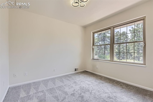 carpeted empty room with baseboards and visible vents