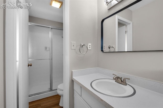 3435 Montebello Dr, Colorado Springs, CO 80918 - full bathroom featuring vanity, a stall shower, toilet, and wood finished floors