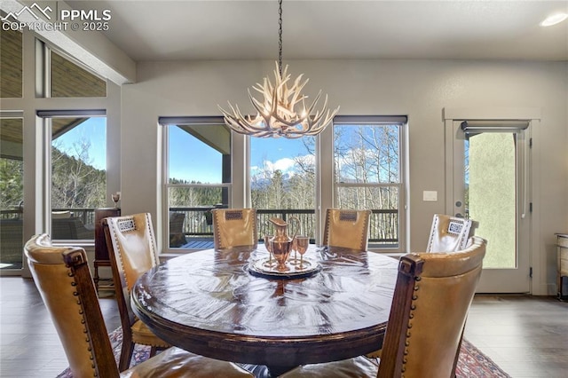 dining space featuring wood finished floors and a notable chandelier