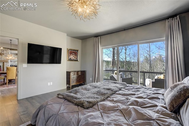 1040 Locklin Way, Woodland Park, CO 80863 - bedroom featuring an inviting chandelier, baseboards, wood finished floors, and access to outside