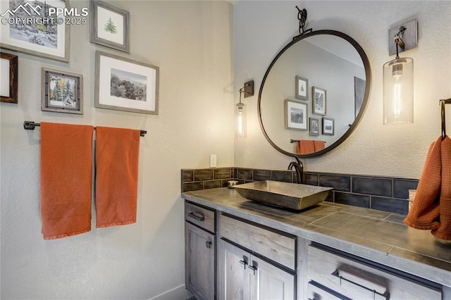 bathroom featuring baseboards, tasteful backsplash, and vanity